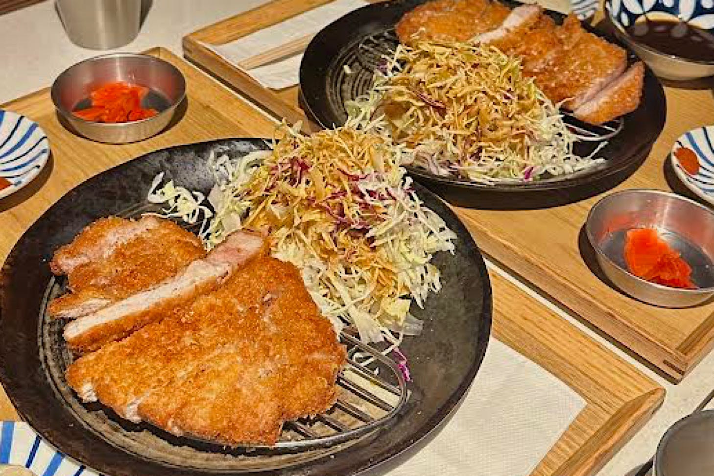 Two plates of krispy katsu with slaw.